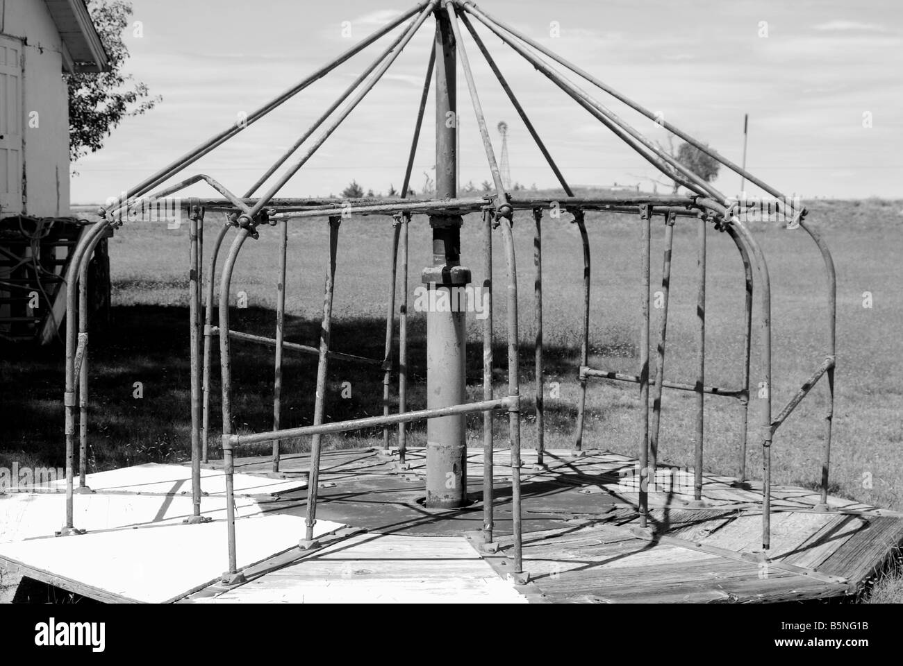 Imagen en blanco y negro de un merry go round en un antiguo patio de recreo Foto de stock