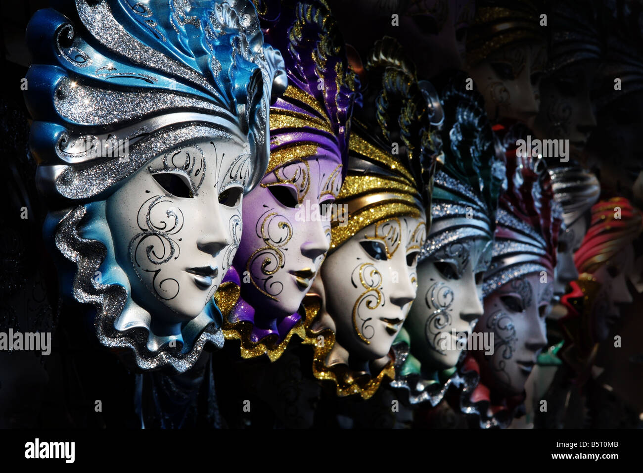 Fila de máscaras venecianas en oro y azul Foto de stock