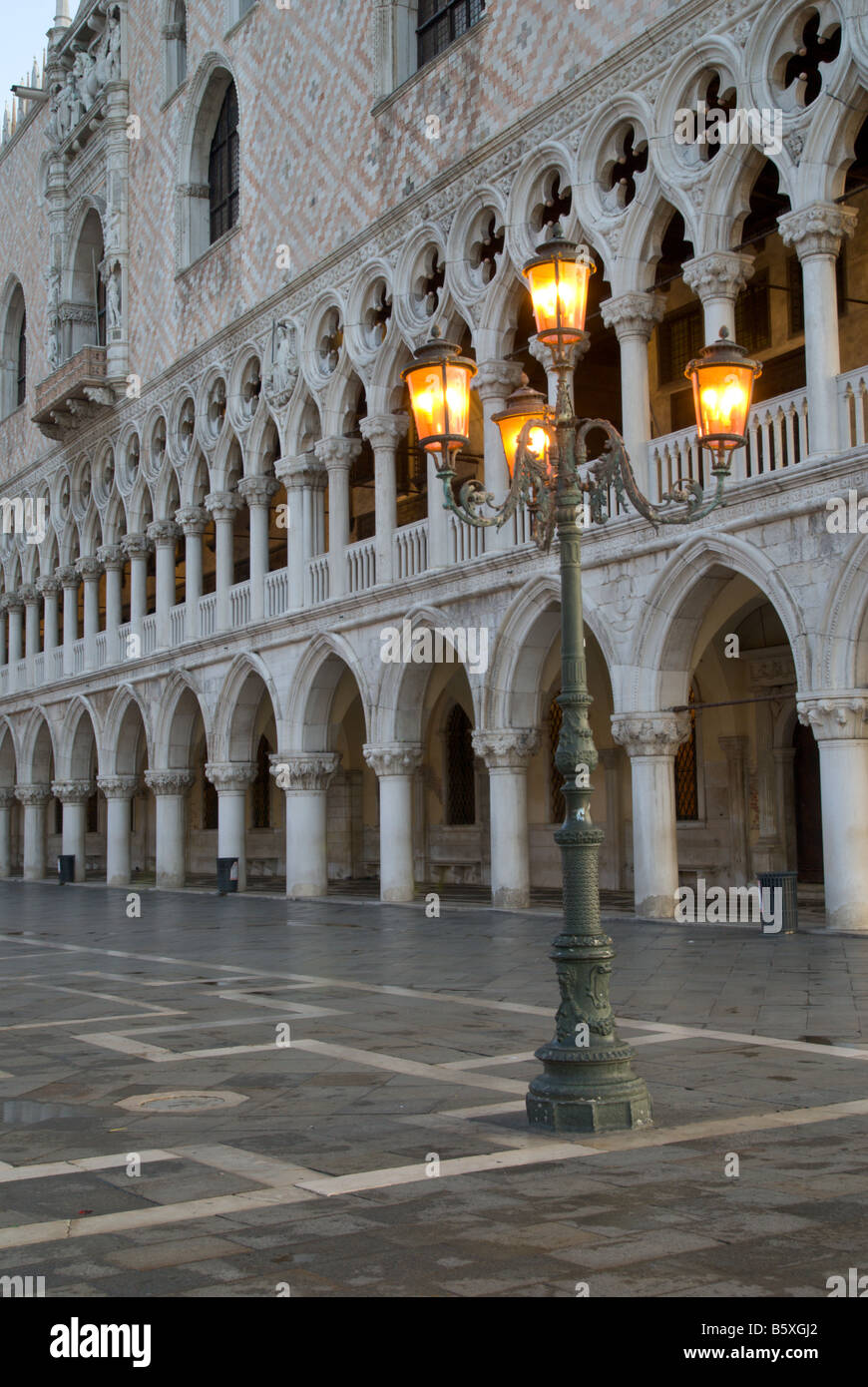 Un poste de la luz en la Plaza de San Marcos Venecia al amanecer detrás de la fachada del Palacio Doge Foto de stock