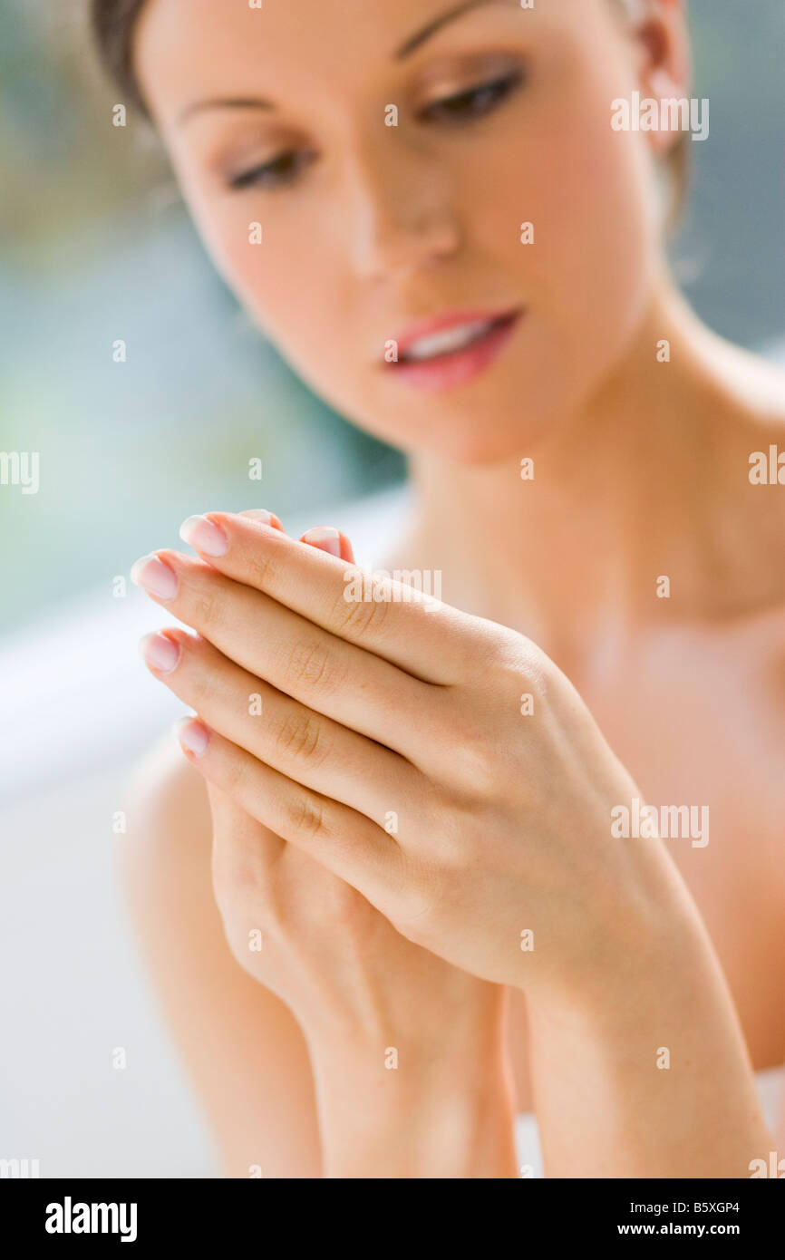 Mujer aplicar crema para manos Foto de stock