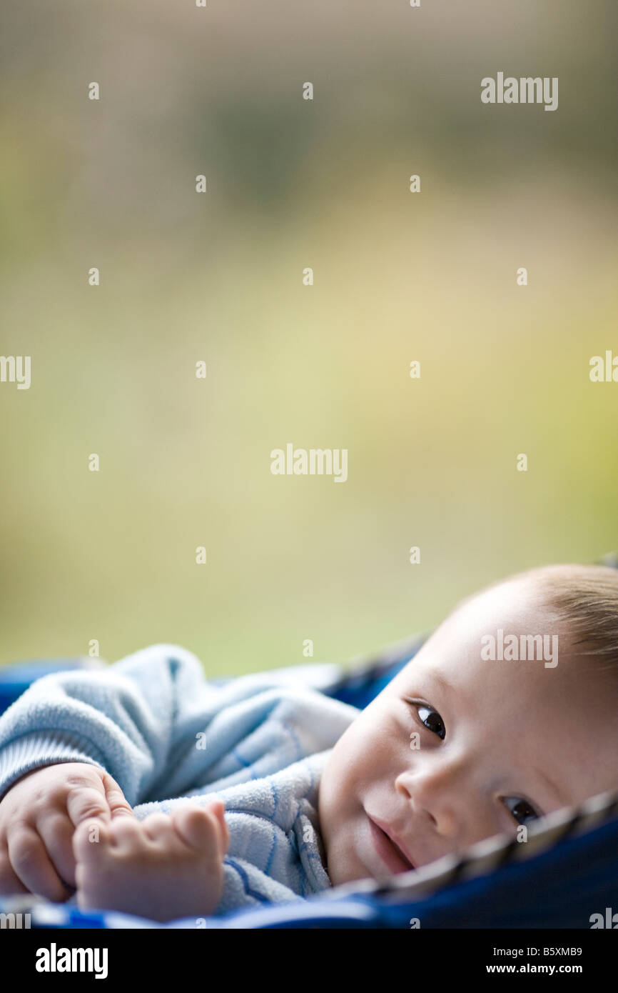 Cinco meses de edad Baby Boy mezcla euroasiática pero mira caucasian recostado en una silla de bebé Foto de stock
