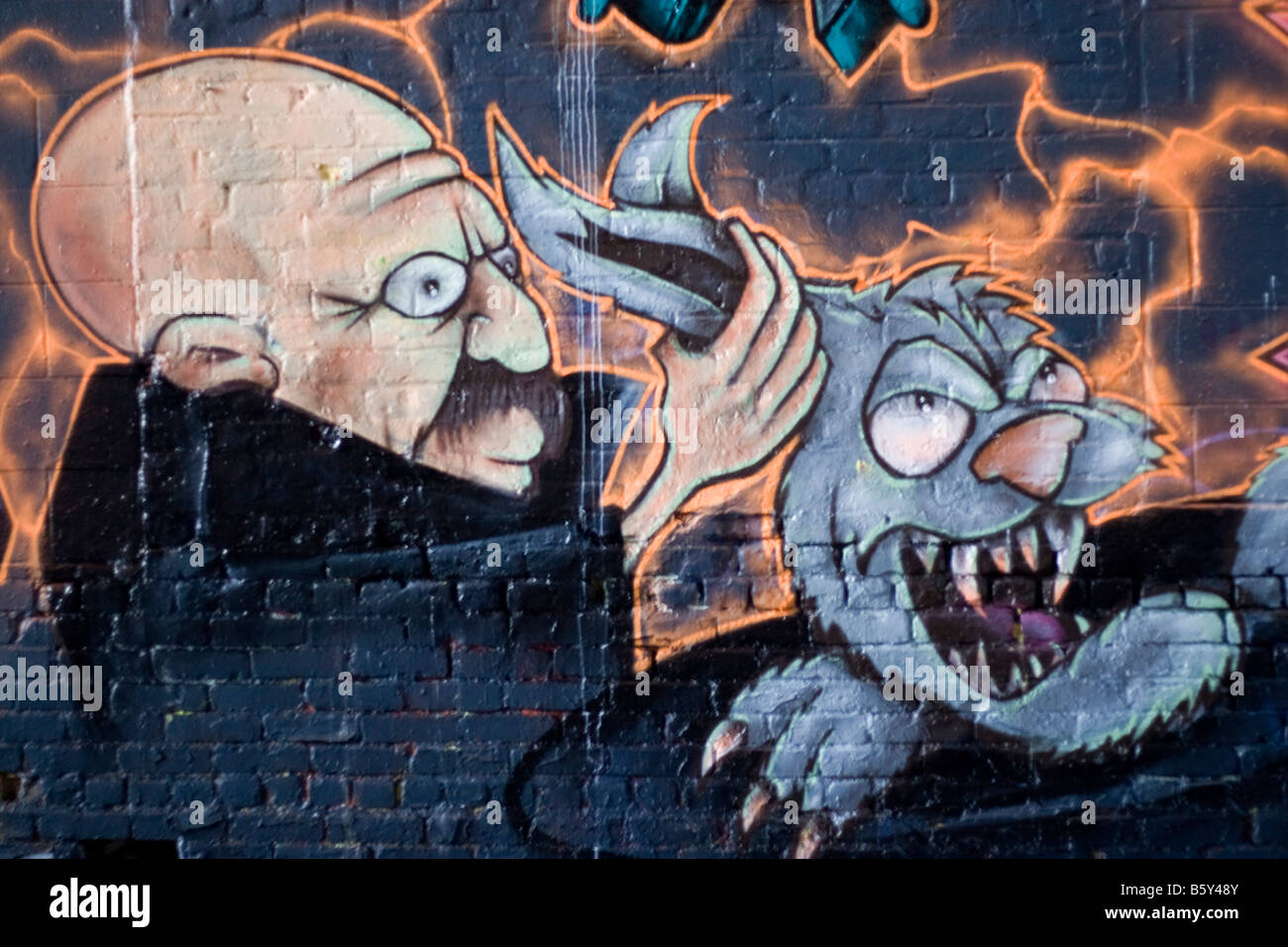 Colorido graffiti pintado con spray en una pared de ladrillo hace un excelente telón de fondo o Foto de stock