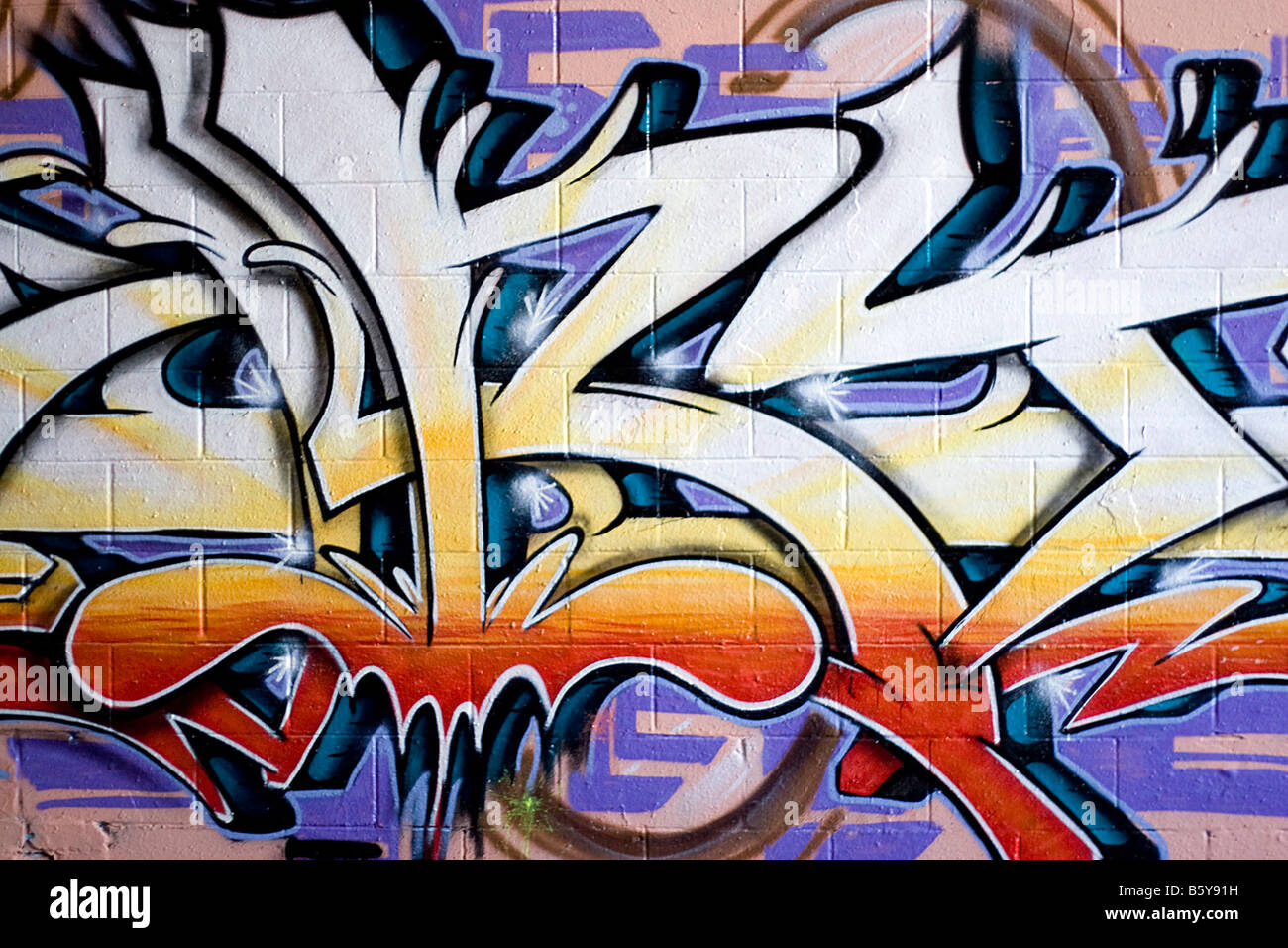 Colorido graffiti pintado con spray en una pared de ladrillo hace un excelente telón de fondo o Foto de stock