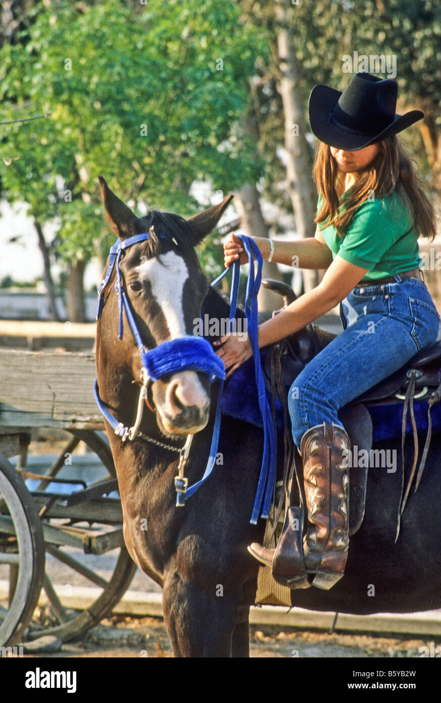 Jovencita en ropa vaquera cabalga su caballo Fotografía de stock - Alamy