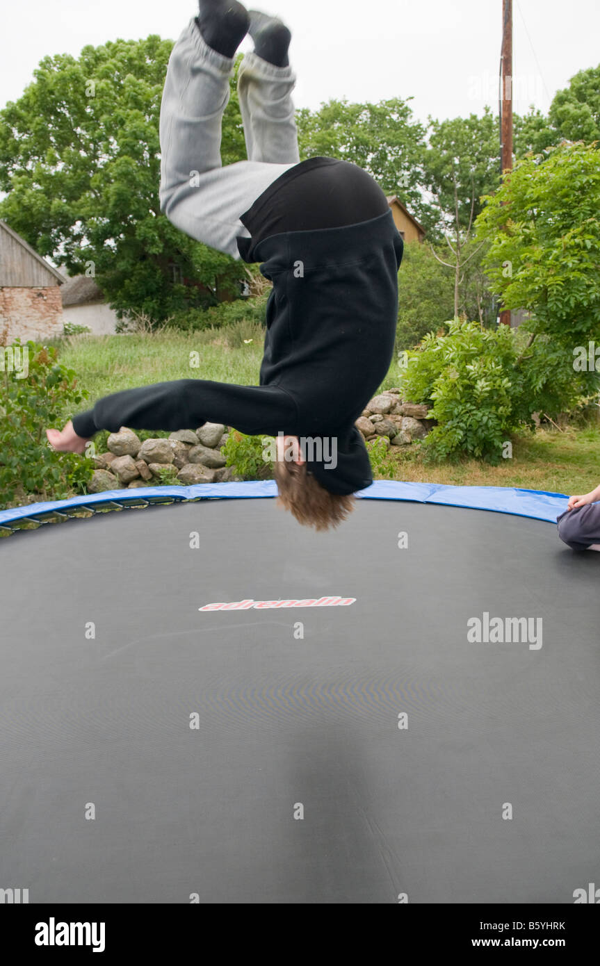Chico saltando sobre un trampolin Fotografía de stock - Alamy