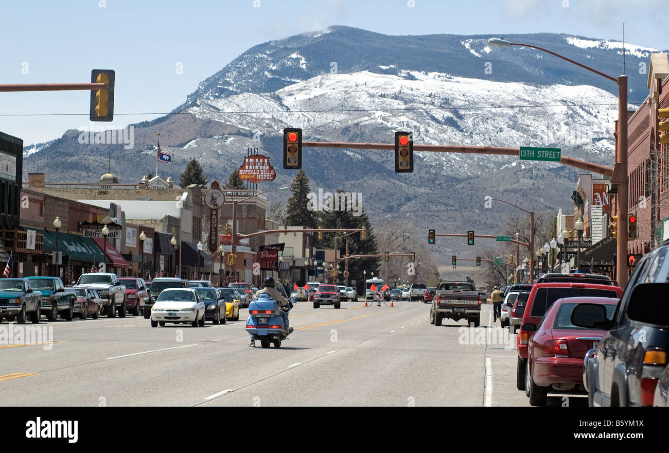 Enmarcado por nevadas montañas rocosas, Sheridan Avenue, la calle principal de Cody, Wyoming, hecha famosa por Buffalo Bill Foto de stock