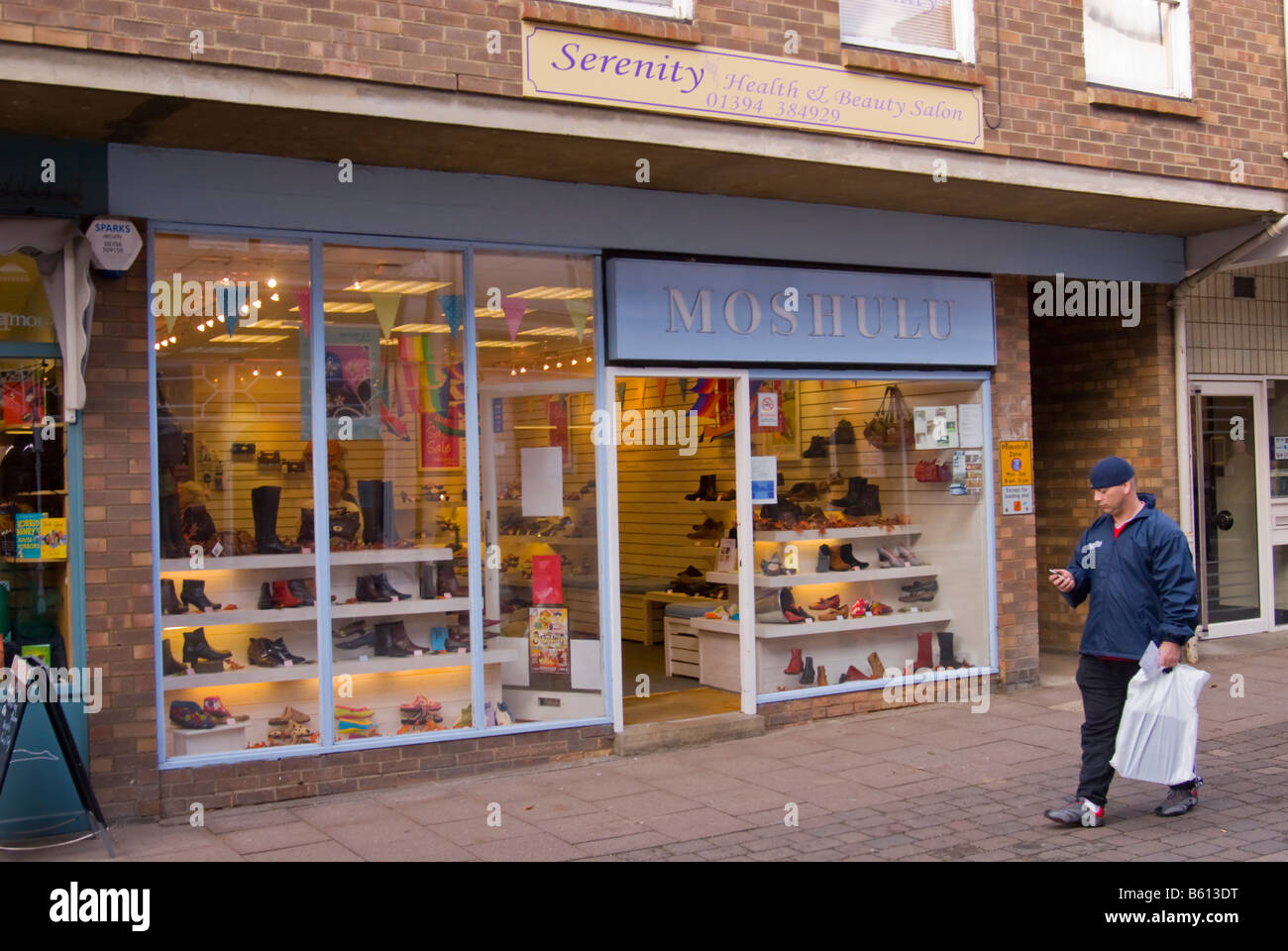 Hombre caminando pasado el Moshulu zapato y calzado tienda en Woodbridge,  Suffolk, UK Fotografía de stock - Alamy