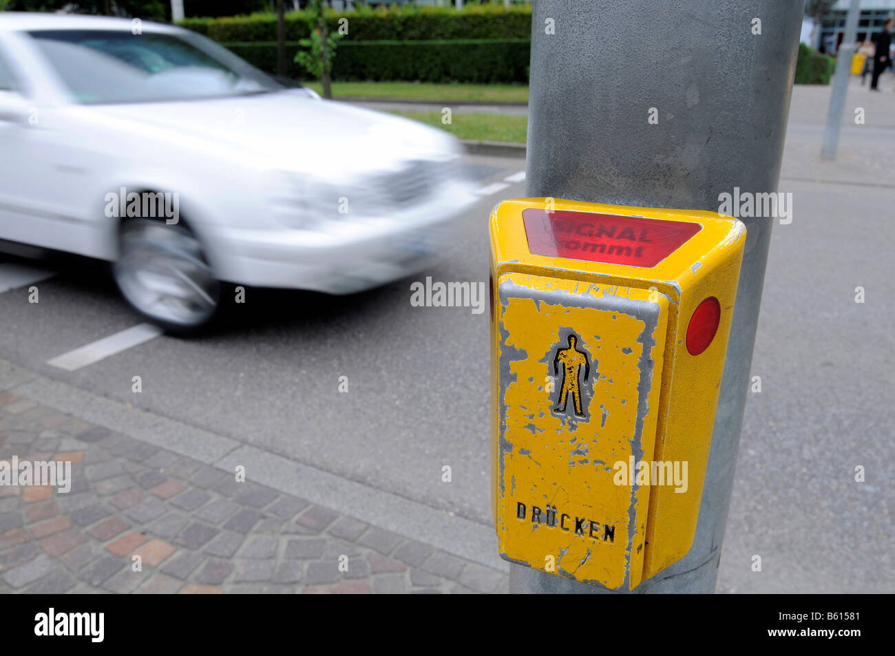 Solicitud de luz de cruce para peatones, la etiqueta del botón 'señal llegando' está encendido, borrosa en la parte posterior de coche, Stuttgart, Baden-Wurtemberg Foto de stock