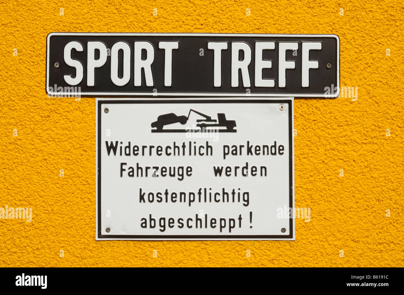 Los signos de la pared amarilla: Sport Treff, Widerrechtlich parkende Fahrzeuge werden kostenpflichtig abgeschleppt!, encuentro deportivo Foto de stock