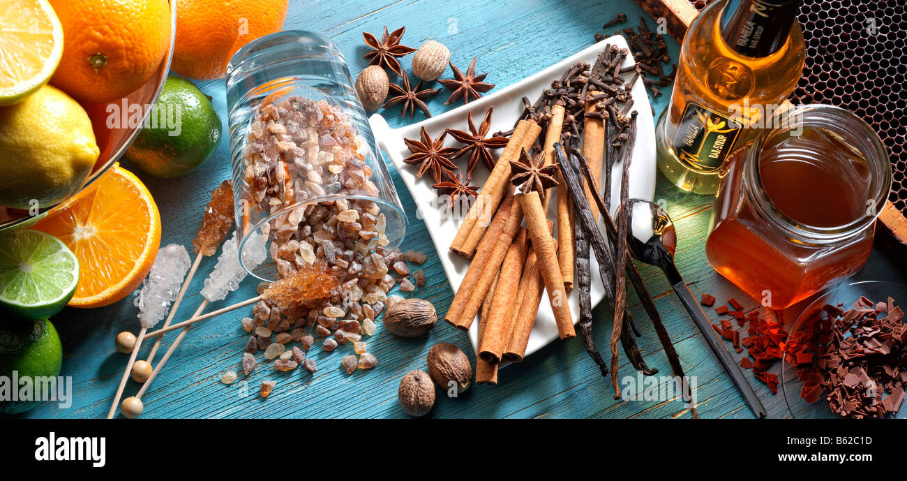 Las especias, frutas, miel, jarabe de azúcar de roca y chocolate sobre una tabla de madera de color turquesa Foto de stock