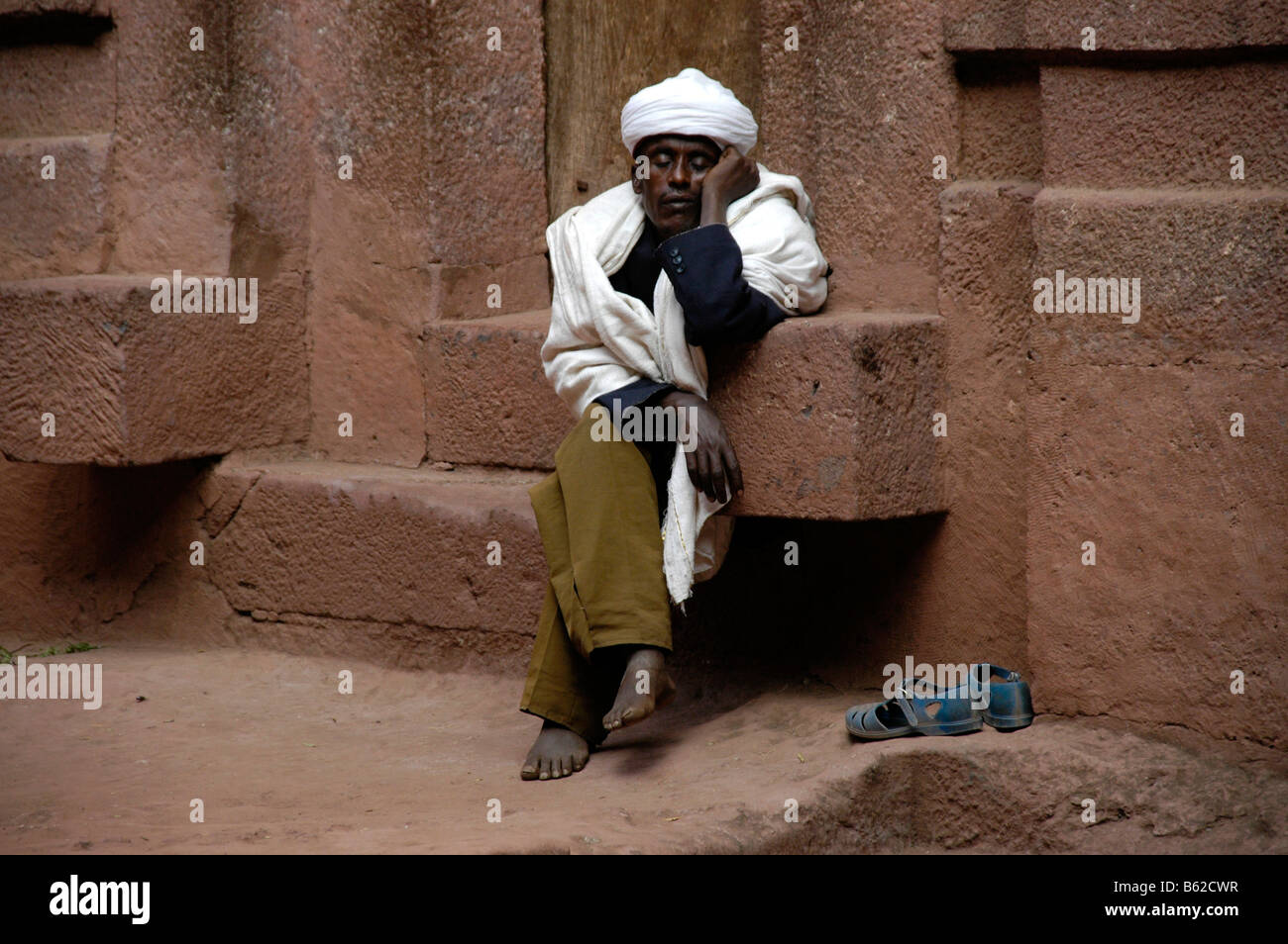 Mann dormitando en los escalones de una iglesia monolítica, Lalibela, Etiopía, África Foto de stock