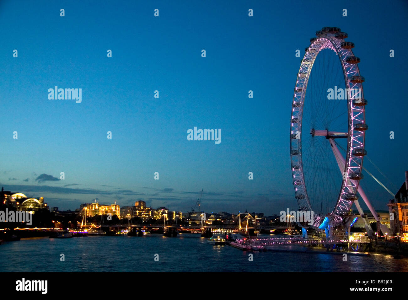 El London Eye de noche junto al río Támesis en Londres, Inglaterra Foto de stock