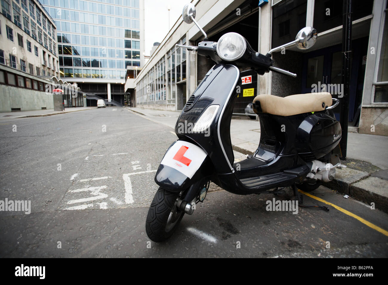 Ciclomotor vespa con L alumno rider placas en Londres England Reino Unido Foto de stock