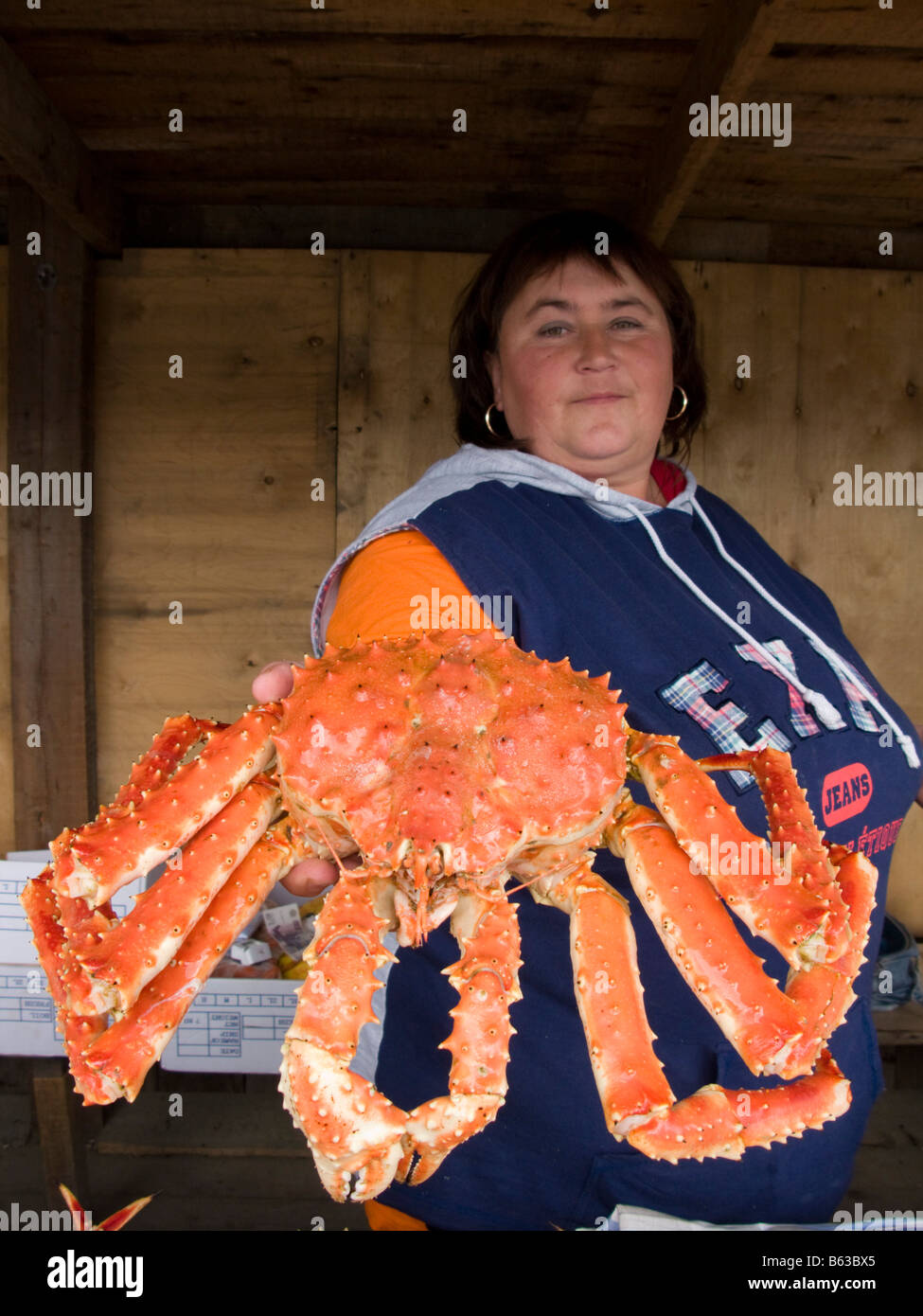 Mujer sosteniendo un gran cangrejo rojo en el Seafood cale en la localidad costera de la isla Sakhalin en Rusia 2008 Foto de stock