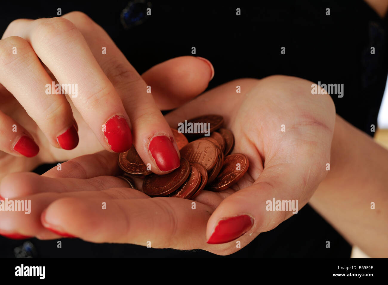 Recuento de monedas de un centavo en la palma de la mano de una mujer. © Mark Shenley Foto de stock