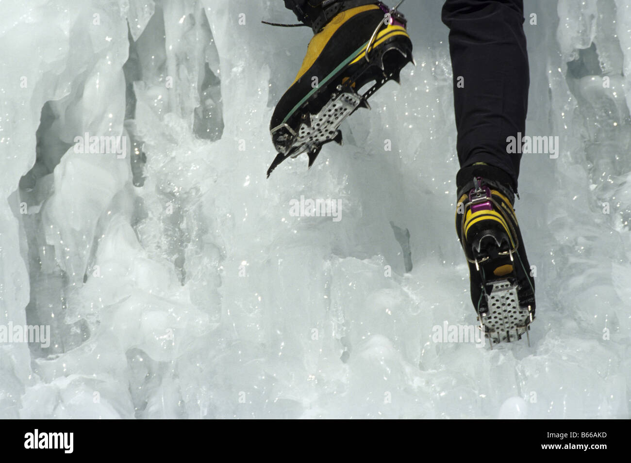 Escalador de hielo con crampones en botas de montaña - fotografía de stock