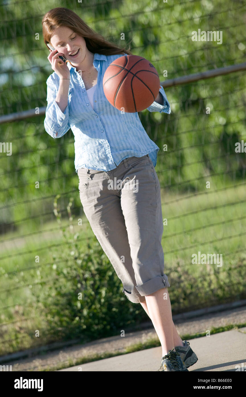 Joven Mujer afroamericana en vestimenta deportiva rebotando una pelota de  baloncesto en la cancha de deportes Fotografía de stock - Alamy