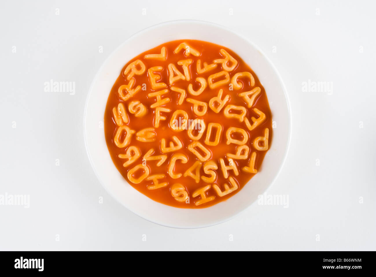 Espaguetis letras deletrear las palabras comer, alimentos y dinero en efectivo, en un recipiente blanco Foto de stock