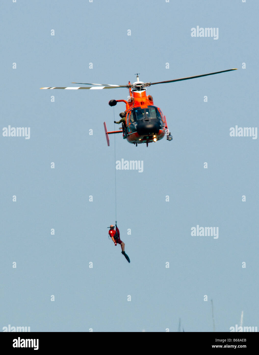 Helicóptero de la Guardia Costera estadounidense y bote de rescate de elevación / nadador de rescate fuera del agua Foto de stock