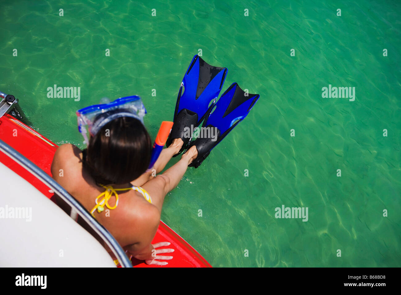 Joven en el equipo de snorkel sentado en barco Foto de stock