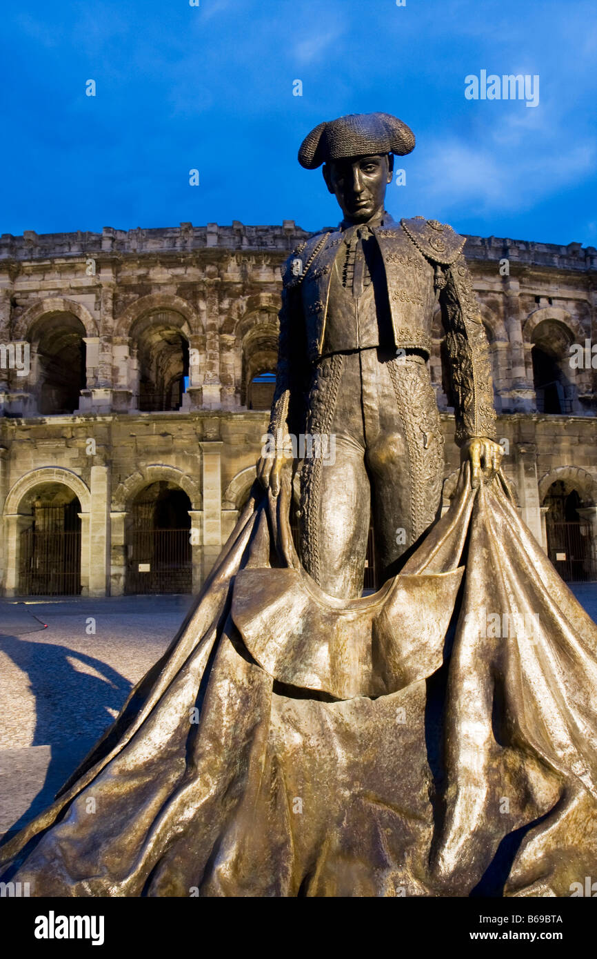 Estatua del torero delante de Arena, en la ciudad francesa de Nimes al anochecer, en el sur de Francia, Europa Foto de stock