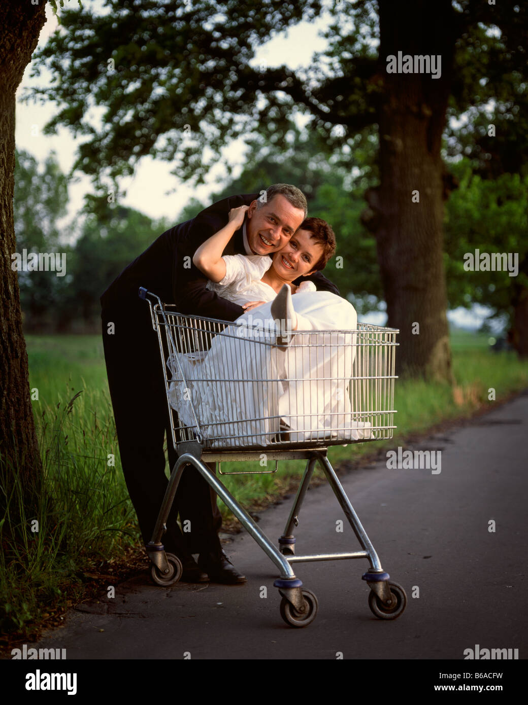 Retrato de recién casados con novia en carrito de compras, Polonia Foto de stock