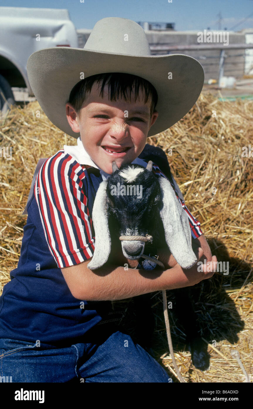 Un joven granjero vistiendo un sombrero de vaquero o stetson con su  mascota, la cabra en la granja de su padre, cerca de Clovis New Mexico  Fotografía de stock - Alamy