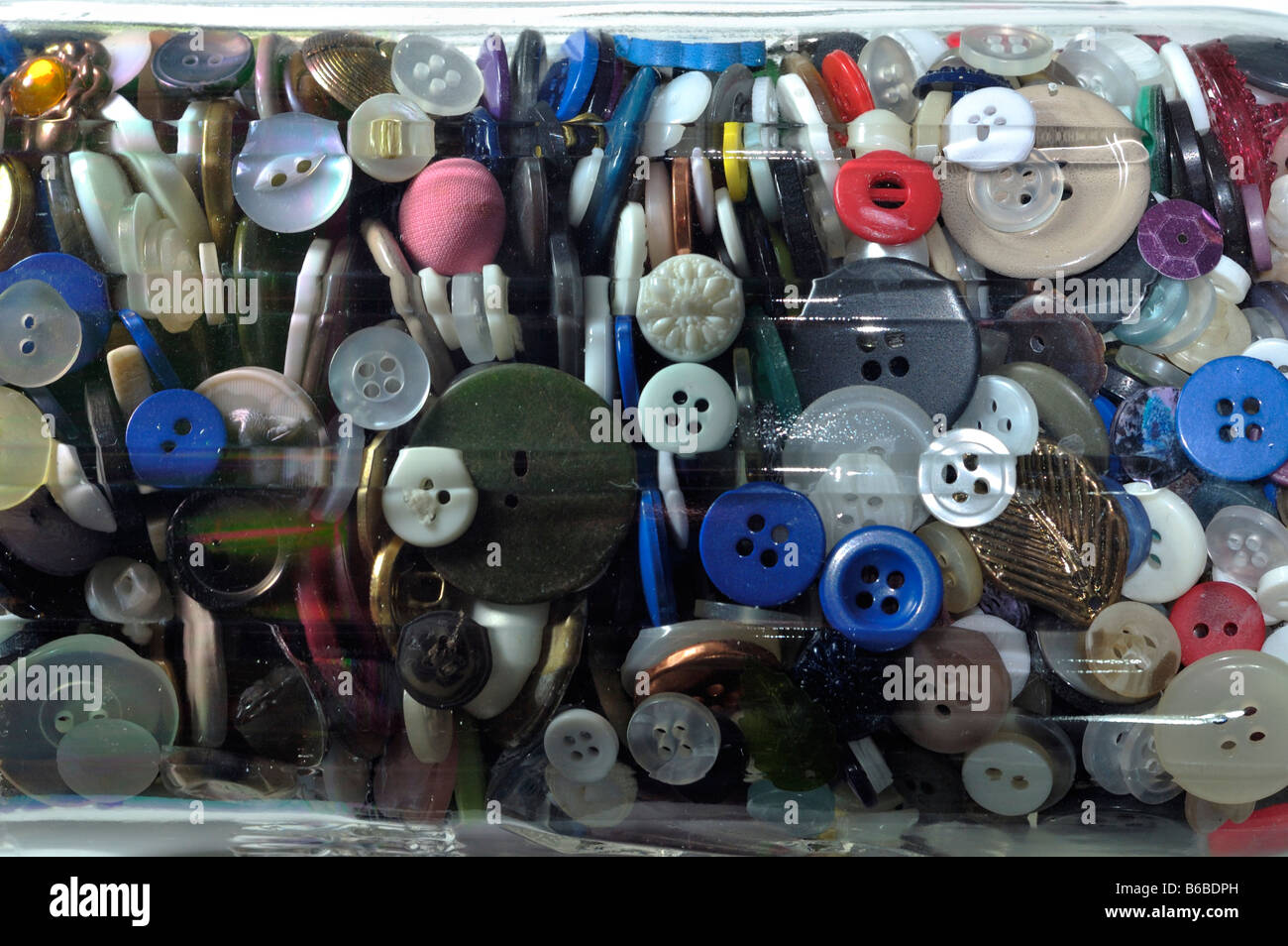 Colección de trajes multicolores botones en un tarro de vidrio Foto de stock