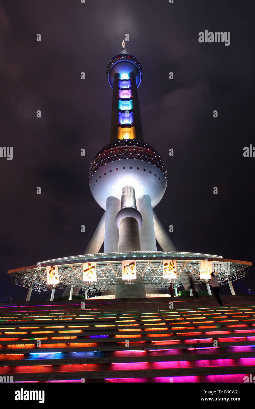 Ángulo de visión baja de la torre de televisión iluminados durante la noche, la Oriental Pearl Tower, Pudong, Shanghai, China Foto de stock
