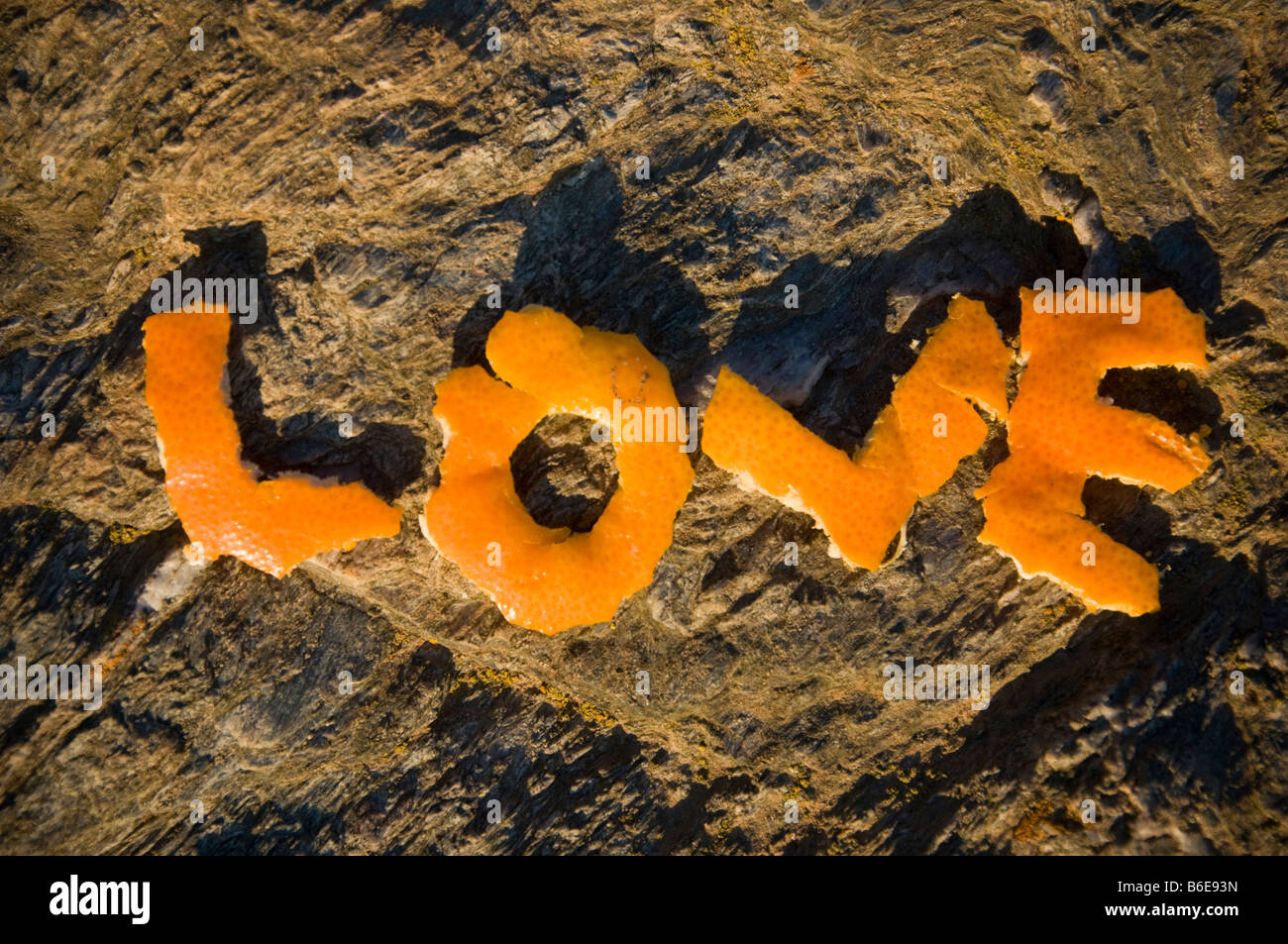 Amor hecha de piel de mandarina sobre una roca Foto de stock