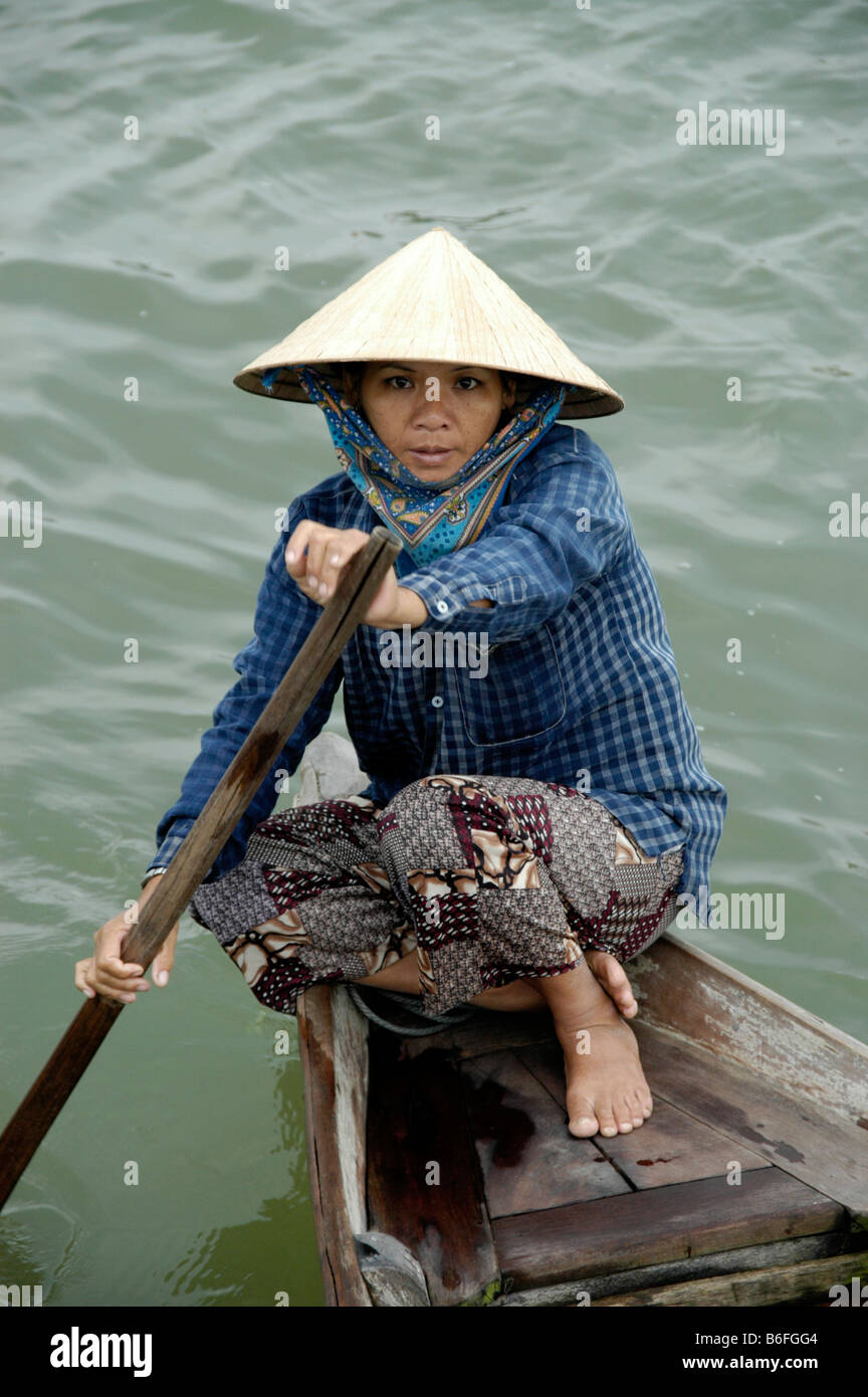 Mujer vistiendo un sombrero en forma de cono, remando un bote, Hoi An,  Vietnam, Sudeste de Asia Fotografía de stock - Alamy