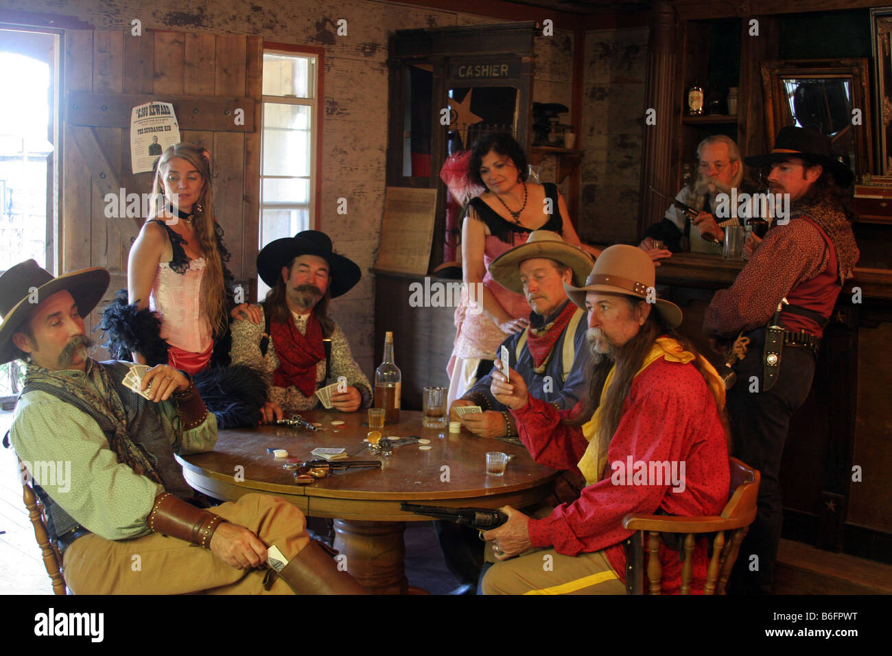 Un vaquero culpables de ACE de su bota mientras juegas al poker en un viejo Western Town Saloon son pistolas tirado Fotografía de stock - Alamy