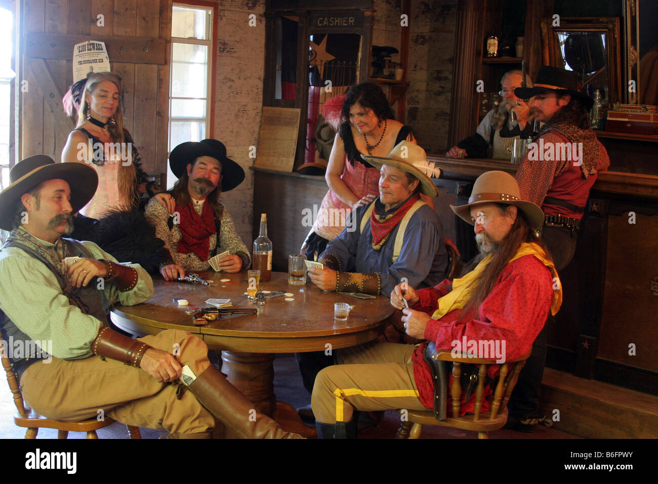 Un vaquero tirando una ACE de su juegas poker en un viejo Western Town Saloon Fotografía de stock - Alamy