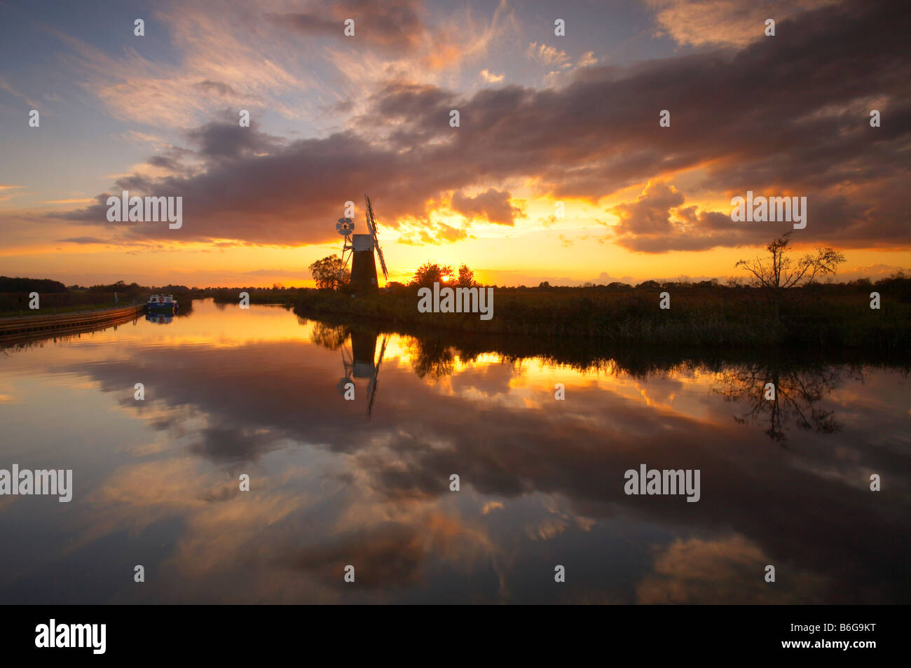 Espectacular atardecer reflejándose en el río Hormiga en el Norfolk Broads, REINO UNIDO Foto de stock