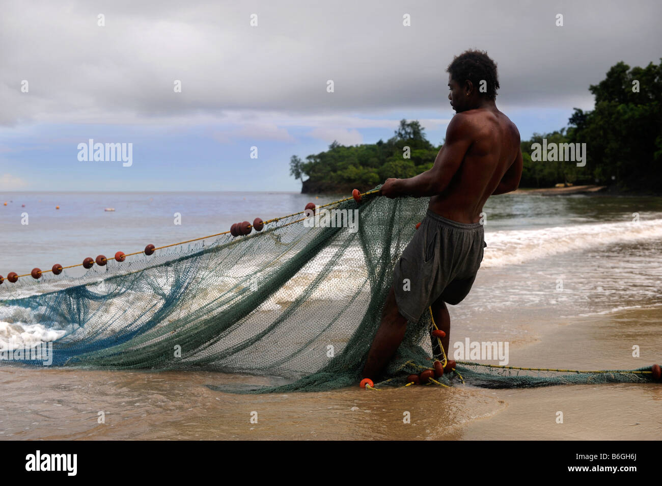 Un pescador artesanal traza en sus redes desde una playa cerca de Castries ST LUCIA Foto de stock