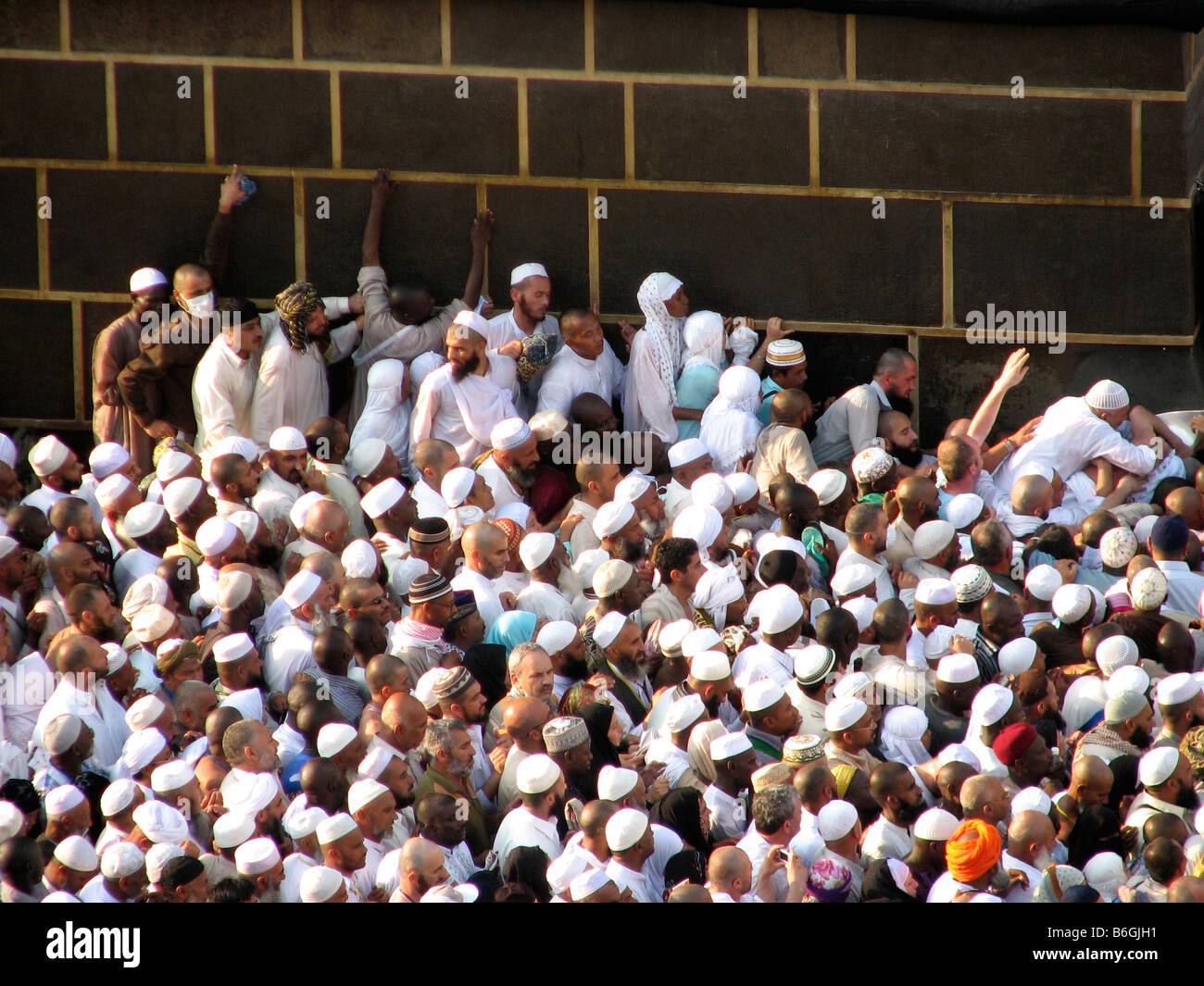 Peregrinos alineándose contra la pared del Kaba tratando de llegar a la esquina donde la piedra negra del paraíso Makkah Arabia Saudita durante el Hajj 2007 Foto de stock