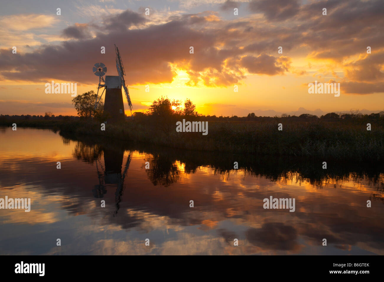 Espectacular atardecer reflejándose en el río Hormiga en el Norfolk Broads, REINO UNIDO Foto de stock