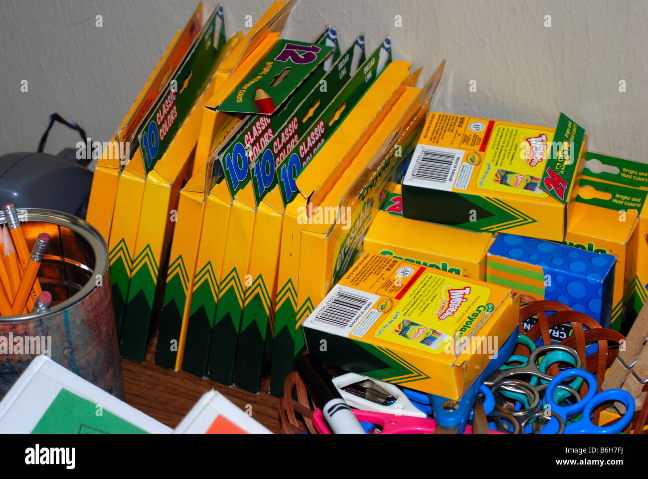 Suministros escolares sentados en un escritorio, incluyendo lápices, tijeras, lápices y marcadores. Foto de stock