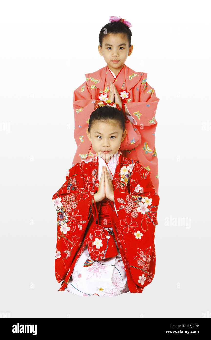 Una chica en kimono de pie detrás de la niña de rodillas Fotografía de  stock - Alamy