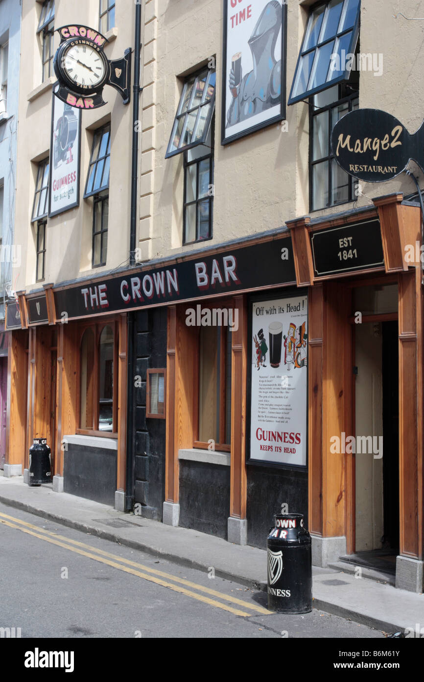 El Crown Bar Wexford con bidones fuera como los ceniceros y Guinness anuncios sobre la fachada Irlanda Foto de stock