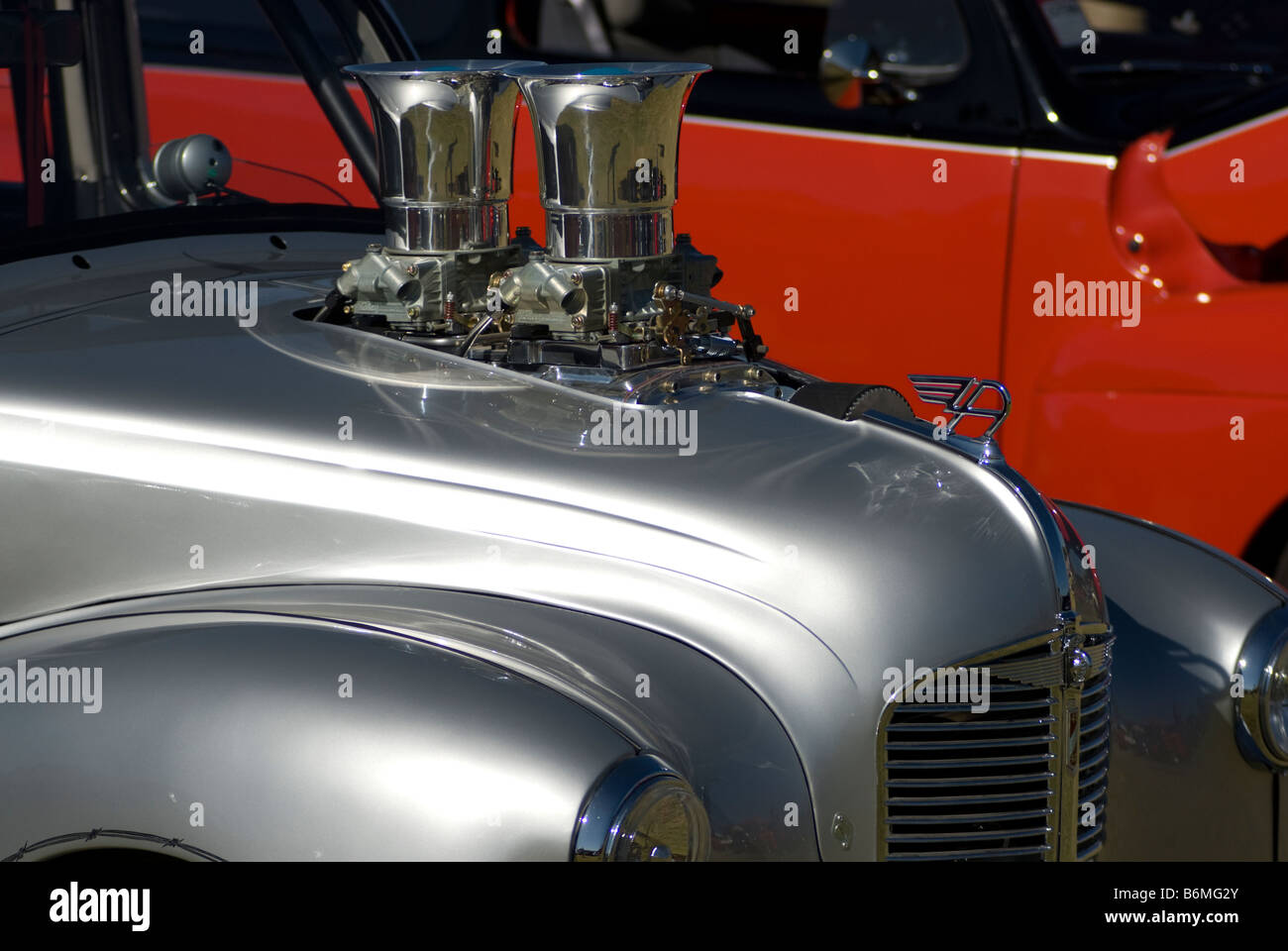 Un motor que sobresale de la parte superior de un antiguo hot rod en un car show. Foto de stock