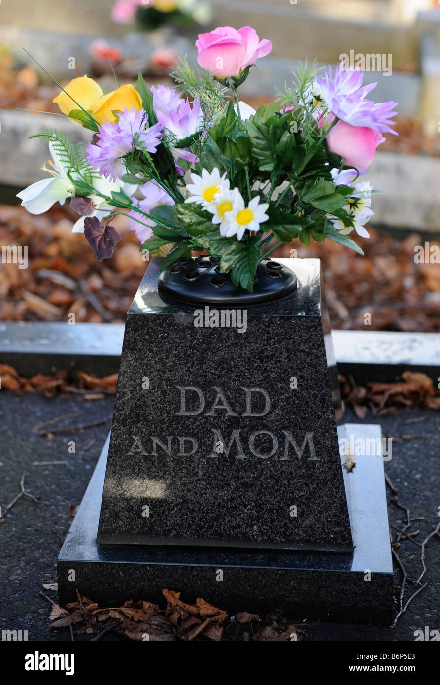 Un ramo de flores en una tumba en memoria de Padres Anónimos inscrito a  Mamá y papá Fotografía de stock - Alamy
