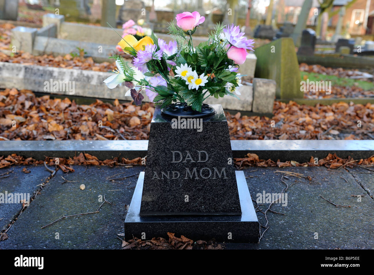 Un ramo de flores en una tumba en memoria de Padres Anónimos inscrito a Mamá y papá Fotografía de stock - Alamy Un ramo de flores en una tumba en memoria de Padres Anónimos inscrito a Mamá y papá Fotografía de stock - Alamy
