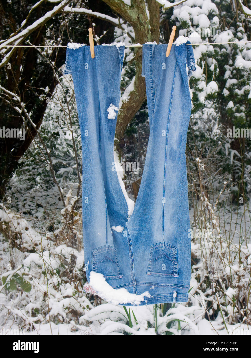 Ropa congelada colgando de una línea de lavado en un jardín cubierto de  nieve en invierno, Gales, Reino Unido Fotografía de stock - Alamy