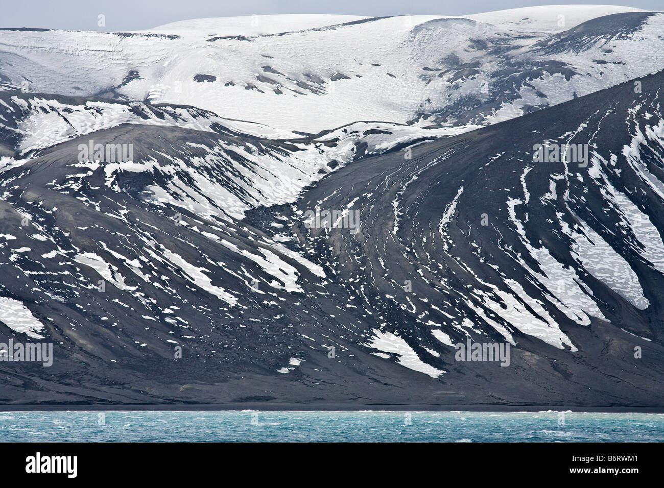 Las rocas volcánicas y cenizas se mezclan con el hielo de los glaciares a orillas de la caldera inundada Isla Decepción, Islas Shetland del Sur Antártida Foto de stock