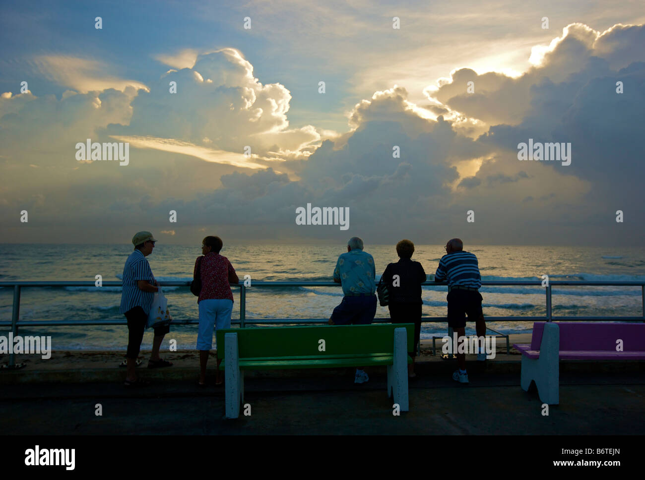 Ancianos jubilados ver el amanecer sobre el océano Atlántico en el Casino de la playa en Lake Worth Florida Foto de stock