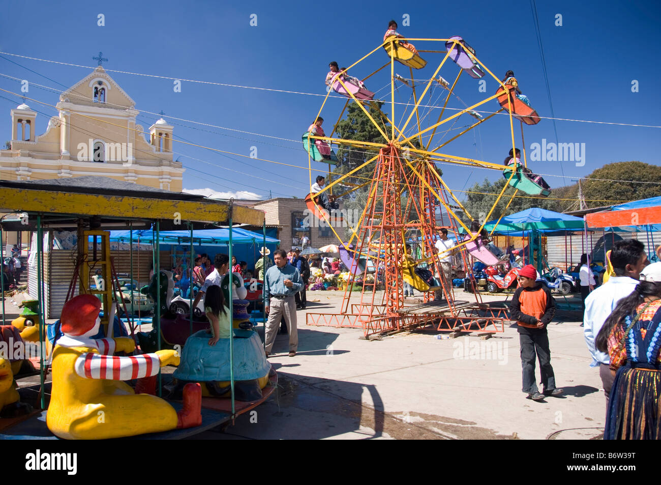 Rueda de Ferris y primitivo merry go round en una feria en Quetzaltenango,  Guatemala Fotografía de stock - Alamy