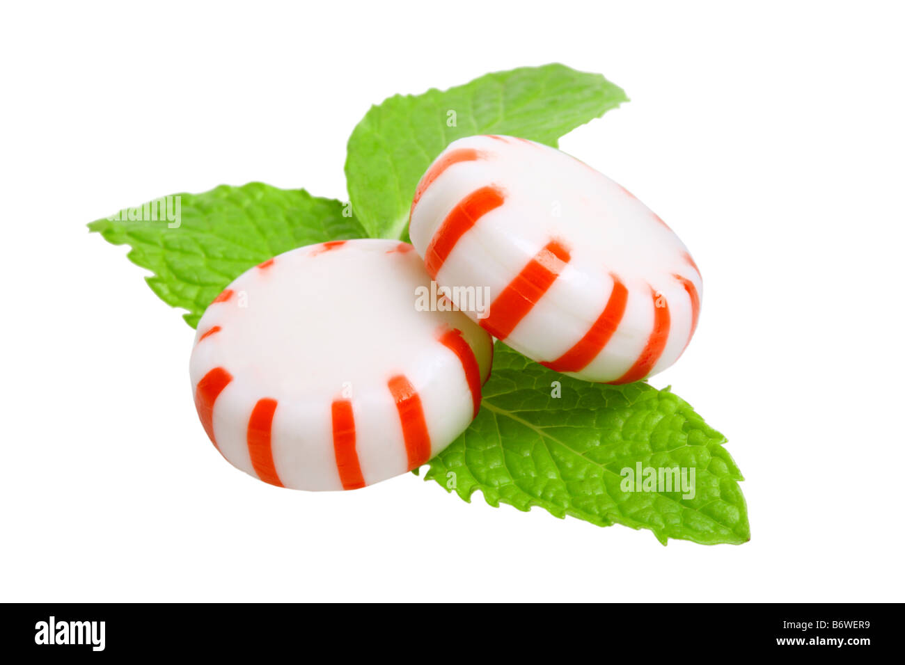 Caramelos de menta y hojas de menta cortadas aislado sobre fondo blanco. Foto de stock