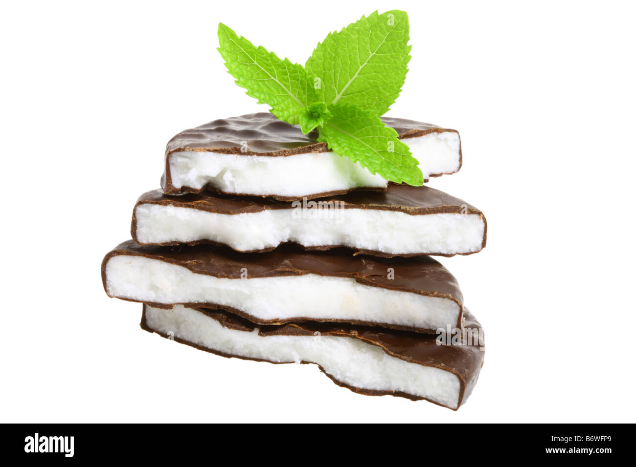 Pila de caramelos de menta y hojas de menta fresca cortada aislado sobre fondo blanco. Foto de stock