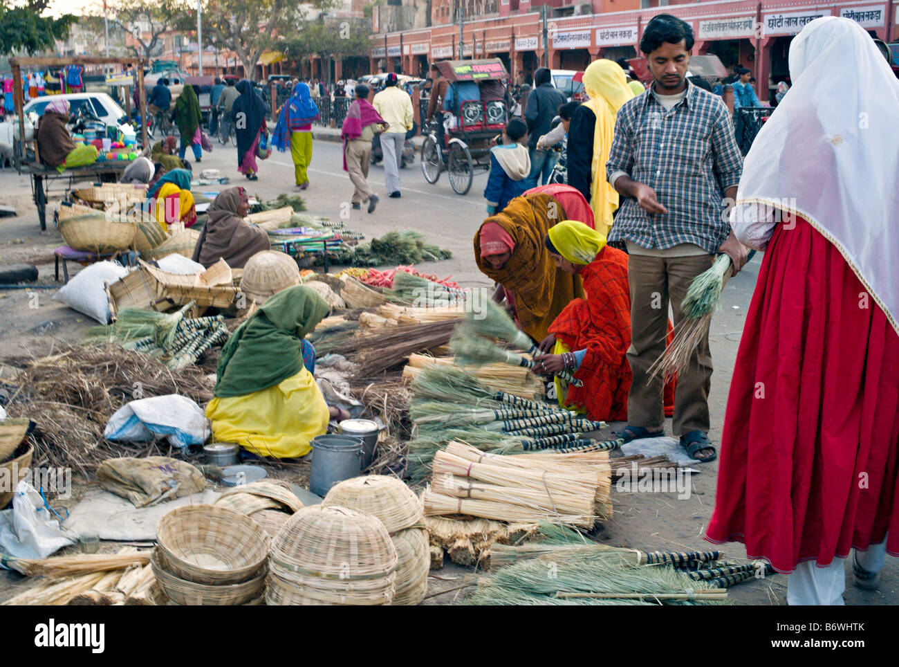 INDIA JAIPUR RAJASTÁN mujeres indias en coloridos saris escobas y canastas  artesanales de venta en la calle en el mercado Fotografía de stock - Alamy